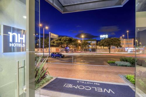 a window view of a parking lot at night at NH Bogota Urban 26 Royal in Bogotá