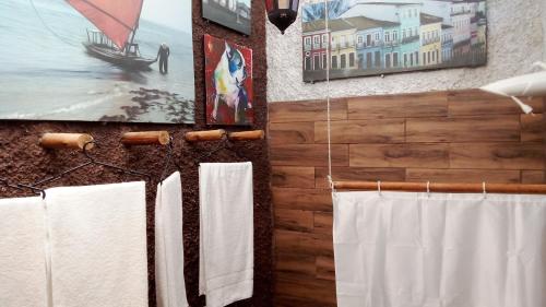 łazienka z białymi ręcznikami wiszącymi na ścianie w obiekcie Casa da Flor Amarela w mieście São Pedro da Aldeia