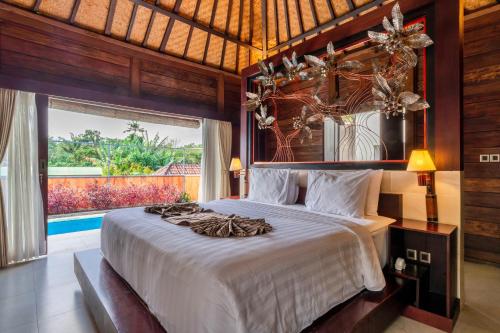 a bedroom with a large bed and a large window at Sri Abi Ratu Villas in Sukawati