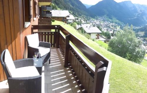 einen Balkon mit 2 Stühlen und einem Tisch mit Aussicht in der Unterkunft Modern apartment in Chatel with fantastic views in Châtel