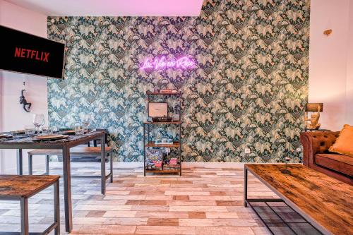 Cette chambre est dotée d'un mur avec un papier peint à fleurs. dans l'établissement Maisonnette Haut de Gamme proche de Disneyland et de Paris, à Neufmontiers-lès-Meaux