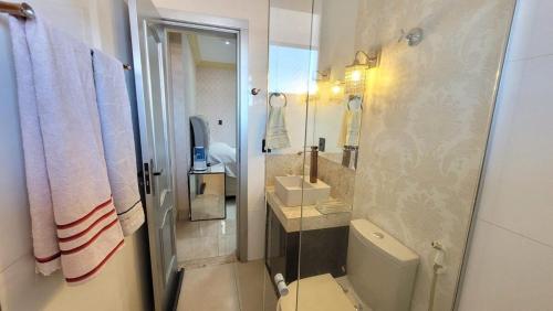 a bathroom with a toilet and a sink and a mirror at Espetacular apartamento no centro in Palmas