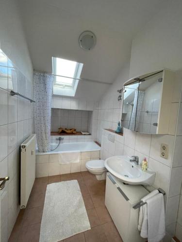 a bathroom with a sink and a toilet and a tub at Alpine Blue Apartments in Griesen
