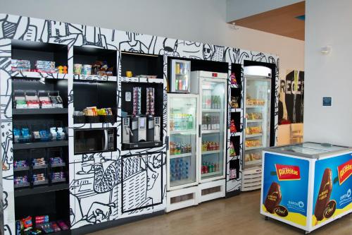 a store with two refrigerators in a room at ibis budget Manhuaçu in Manhuaçu