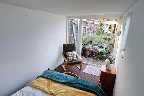 um quarto com uma cama, uma cadeira e uma janela em Beautiful Spacious 5 Bed House em Fornham Saint Martin