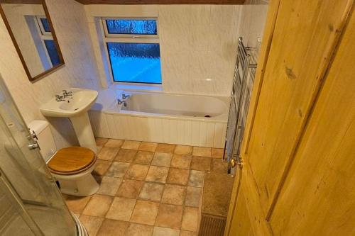 uma casa de banho com uma banheira, um WC e um lavatório. em Beautiful Spacious 5 Bed House em Fornham Saint Martin