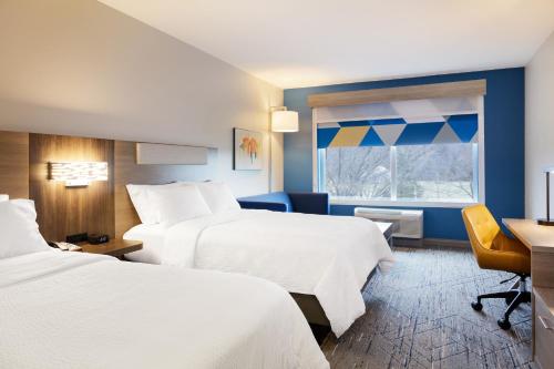 Habitación de hotel con 2 camas, escritorio y ventana en Holiday Inn Express Fremont, an IHG Hotel, en Fremont