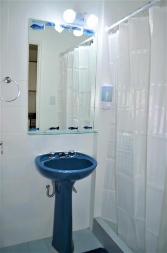 a bathroom with a blue sink and a mirror at Amar el mar in Puerto Madryn