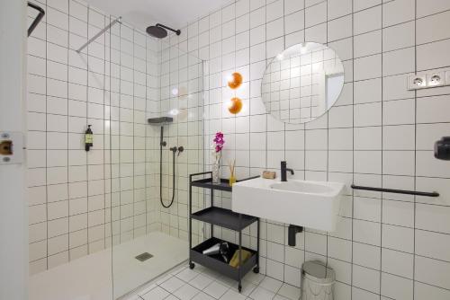マドリードにあるPlaza España Princesa - Apartamento de 1 dormitorioの白いタイル張りのバスルーム(シンク、シャワー付)