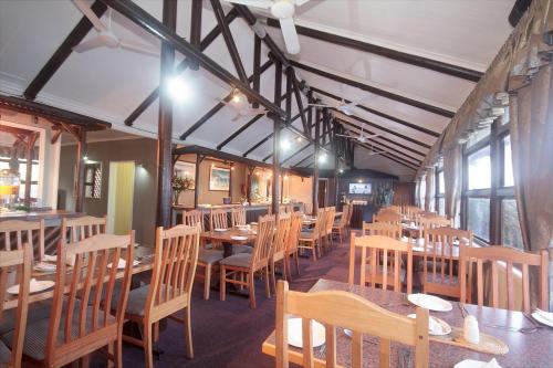 a dining room with wooden tables and chairs at Pine Lodge Resort in Port Elizabeth