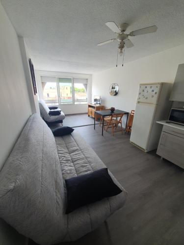 ein Schlafzimmer mit Bett und eine Küche mit Tisch in der Unterkunft LES FLORALIES 2 Studio 4 personnes climatisé, piscine dans la résidence et Parking privé disponible in Le Grau-du-Roi