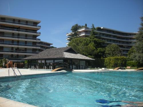 une grande piscine avec un bâtiment en arrière-plan dans l'établissement BELLES TERRES AP4378 By Riviera Holiday Homes, à Nice
