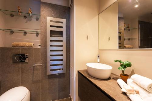 une salle de bain avec un lavabo, des toilettes et un miroir dans l'établissement BELLES TERRES AP4378 By Riviera Holiday Homes, à Nice