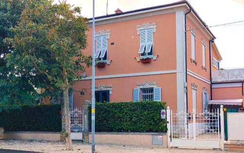 une maison orange avec des fenêtres blanches et une clôture dans l'établissement Villa Liberty B&B, à Fano