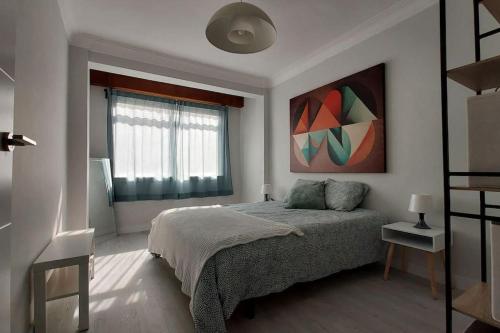 a bedroom with a bed and a painting on the wall at Apartamento Torre de Hércules in A Coruña