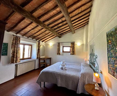 een slaapkamer met een bed in een kamer met houten plafonds bij L'Aiolina in Vagliagli