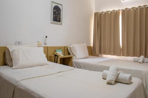 ein Zimmer mit 2 Betten und einem ausgestopften Tier auf dem Bett in der Unterkunft Inácios Hotel ltda in Redenção