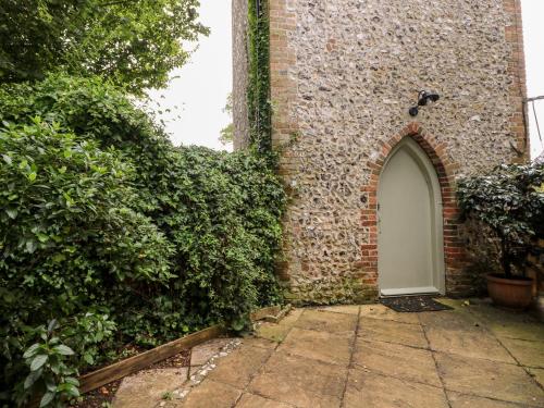 a brick building with a white door and ivy at Hapton Folly in Waterlooville