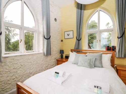 a bedroom with a large bed with two windows at Hapton Folly in Waterlooville