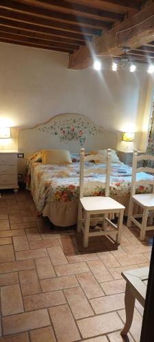 a bedroom with a bed and two chairs in it at Agriturismo Villa Le Vigne in Montevarchi