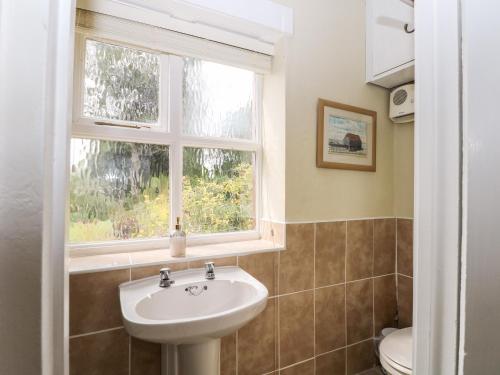 uma casa de banho com um lavatório e uma janela em Hapton Folly em Waterlooville