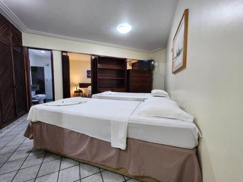 a bedroom with a large white bed in a room at Pizzato Praia Hotel in Natal