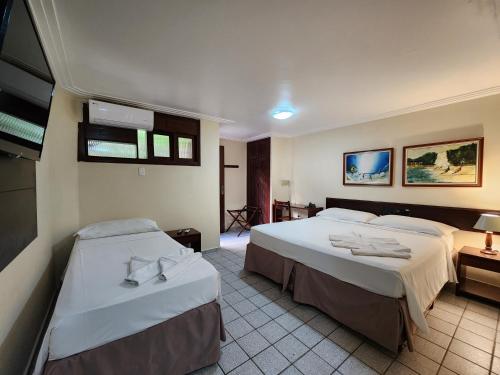 a hotel room with two beds in a room at Pizzato Praia Hotel in Natal