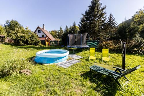 a backyard with a pool and chairs and a picnic table at Chata Bart in Krásný Les