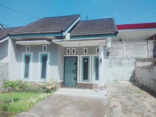 a house with a green door and a fence at D'House Homestay in Palembang