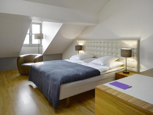 sypialnia z dużym łóżkiem i krzesłem w obiekcie The ICON Hotel & Lounge w Pradze