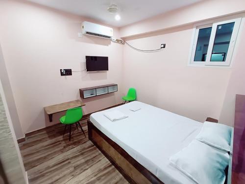a bedroom with a bed and a desk and a tv at Hotel A R S in Patna