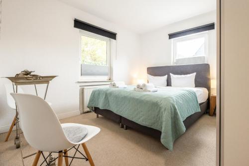 a bedroom with a bed and a desk and a chair at Appartement Pier 13 in Tinnum