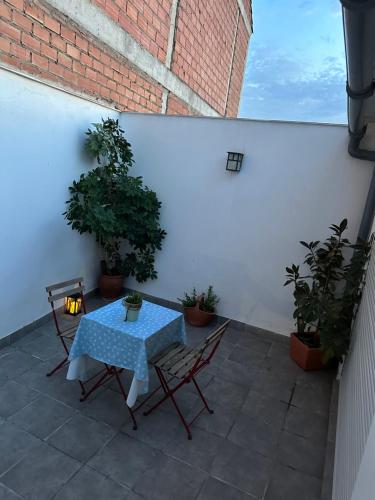 une table et des chaises sur une terrasse agrémentée de plantes dans l'établissement Encantador piso en Villafranca, à Villafranca de Córdoba