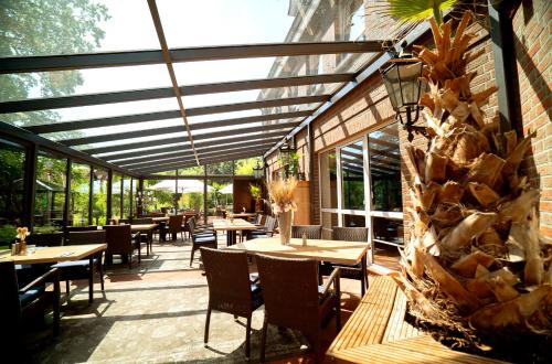 un patio avec des tables et des chaises dans un restaurant dans l'établissement Wildeshauser Hof, à Wildeshausen