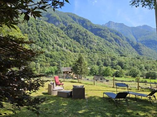 um grupo de cadeiras e mesas em frente a uma montanha em Verzasca: Casa Sonia em Frasco