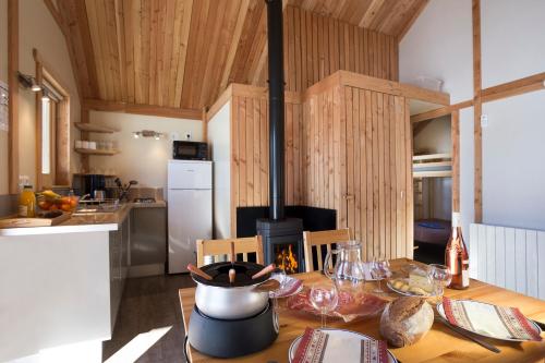 uma cozinha com uma mesa de madeira e um fogão em Huttopia Vallouise em Vallouise