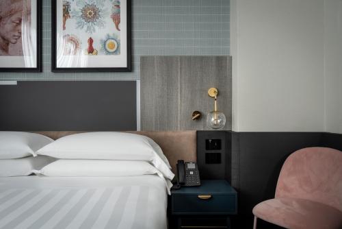 a bedroom with a bed and a phone on a table at iQ Hotel Firenze in Florence