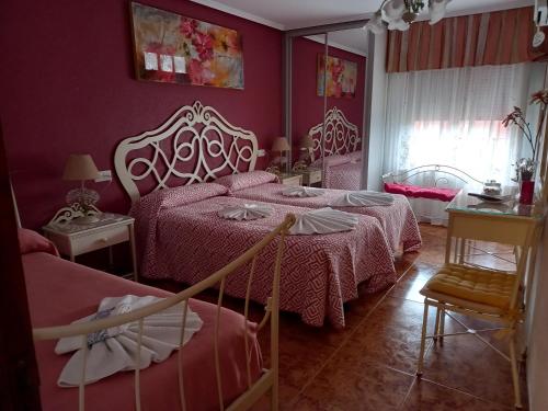 Hostal Camino de Santiago في فورميستا: غرفة نوم بسريرين ومرآة
