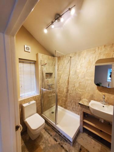 La salle de bains est pourvue de toilettes, d'une douche et d'un lavabo. dans l'établissement 5 bedroom, recently renovated house close to Hastings Beach, à Hastings