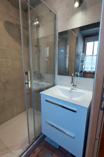 une salle de bain avec un lavabo blanc et une douche dans l'établissement Le Bois Haut, à Saint-Jacques-des-Blats