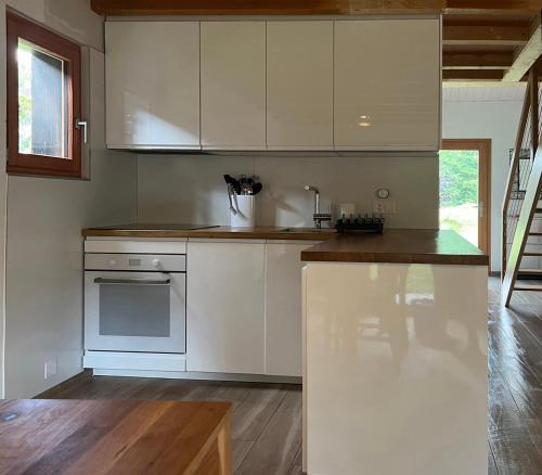 eine Küche mit weißen Schränken und einer Arbeitsplatte in der Unterkunft Chalet près des bisses in Savièse