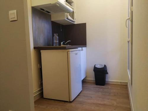 une petite cuisine avec un évier et un réfrigérateur dans l'établissement le balcon Haendel, à Lucé