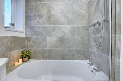 a bathroom with a white tub and a shower at Stunning 3 bed House in Central Hull in Hull