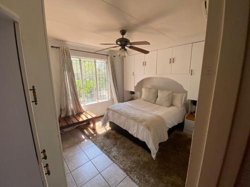 a bedroom with a bed and a ceiling fan at HomeSweetHome City Apartment in Nelspruit