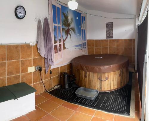 ein Bad mit einer Holzbadewanne in einem Zimmer in der Unterkunft The hidden Place in Alcaudete