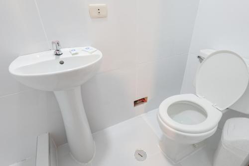 a white bathroom with a sink and a toilet at Amakonkay Machupicchu in Machu Picchu