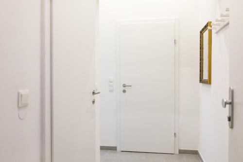 eine Gruppe weißer Türen in einem Zimmer in der Unterkunft Vienna-flats | contactless check-in in Wien
