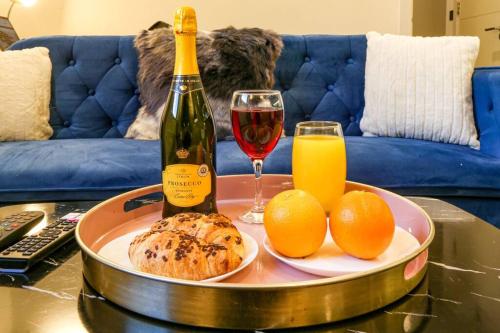 a bottle of wine and oranges on a table at Luxury Apartment - Close to City Centre - Free Parking, Fast Wifi, SmartTV with Sky and Netflix by Yoko Property in Milton Keynes