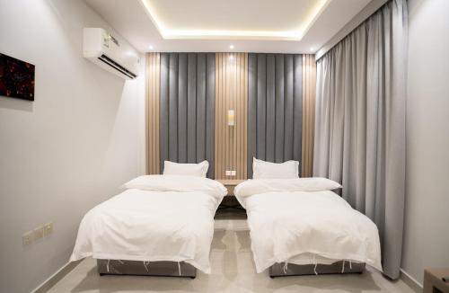 2 camas en una habitación de hospital con cortinas en البرج الازرق شقق فندقية Alburj Alazraq, en Riad