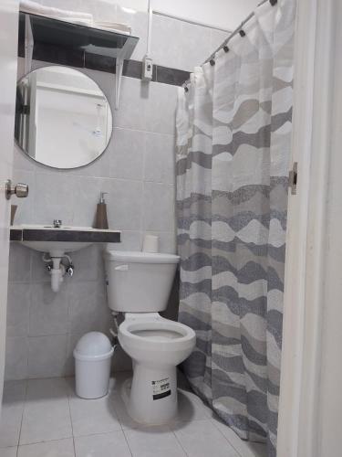 a bathroom with a toilet and a shower curtain at Casa Mercedes in Valladolid